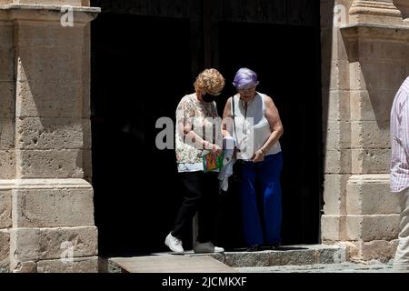 Zwei alte Frauen, die aus einer Kirche hervorgehen. Stockfoto