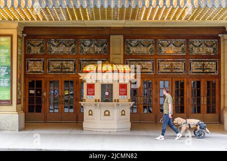 Ein Mann mit Hund im Rollstuhl geht an der Fassade des Elgin and Winter Theaters in der Yonge Street im Stadtzentrum vorbei. Stockfoto