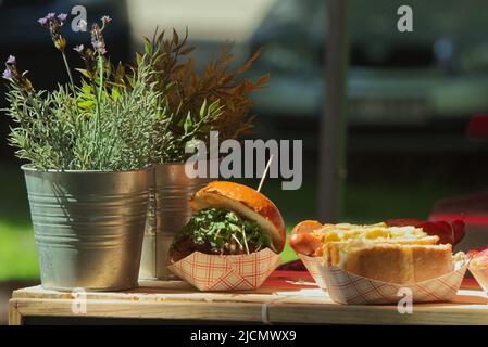 Frisch zubereiteter Burger und Hot Dog locken Besucher auf den Bauernmarkt Stockfoto