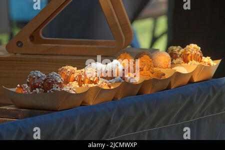 Leckere kleine Mini-Donuts mit verschiedenen Belägen auf dem Bauernmarkt in Prag Stockfoto