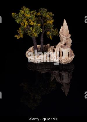 Bonsai-Miniaturbaum in einem Keramiktopf, isoliert auf Schwarz Stockfoto