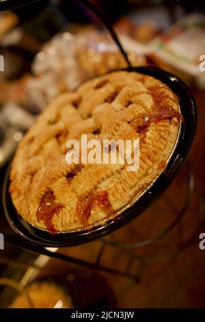 Whole Strawberry Rhabarb Pie, verziert mit Gitterkruste auf einem dunklen Holztisch, Landschaftsansicht von oben, Nahaufnahme, schräg. Stockfoto