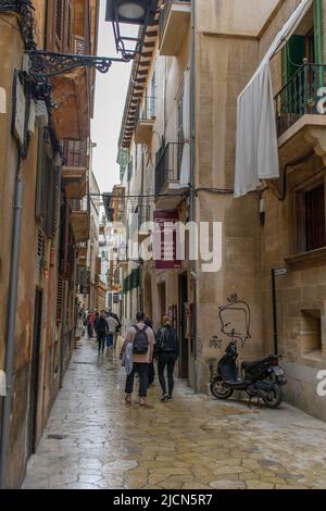 Palma de Mallorca, Mallorca, Spanien - 05.03.2022: Menschen, die in engen Gassen von Palma de Mallorca spazieren Stockfoto