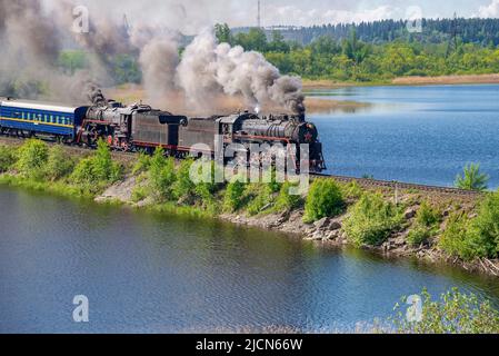 RUSKEALA, RUSSLAND - 11. JUNI 2022: Dampflokomotive mit einem Retro-Touristenzug 'Ruskeala Express' auf dem Damm des Karmalanyarvi-Sees. Republik Karelien Stockfoto