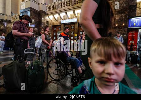 Kiew, Kiew, Ukraine. 14.. Juni 2022. Eine ältere ukrainische Frau mit einer Behinderung und andere Fahrgäste warten in Kiew auf Züge, da die Menschen nach der russischen Invasion in das Land in ihre vom Krieg verwüsteten Heimatorte in der Ukraine zurückgekehrt sind. (Bild: © Daniel Ceng Shou-Yi/ZUMA Press Wire) Stockfoto