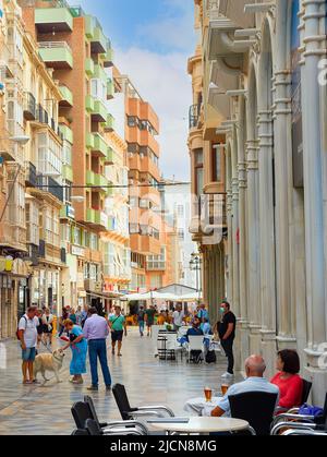 CARTAGENA, SPANIEN - 1. NOVEMBER 2021: Überfüllte zentrale Einkaufsstraße mit Cafés, Spaziergänger, moderner Architektur Stockfoto