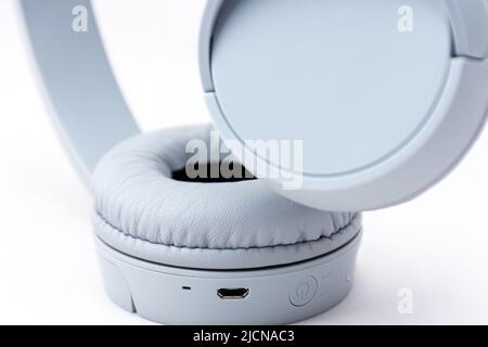Nahaufnahme von grauen kabellosen Kopfhörern, isoliert auf weißem Hintergrund. Stockfoto