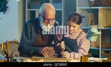 Fürsorglicher Großvater mit seiner Enkelin im Teenage-Alter verbringt Zeit miteinander. Hobby Stockfoto