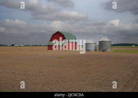 Landwirtschaftliche Szene mit einer roten Scheune und zwei Silos umgeben von einem frisch gepflügten Feld in Ohio Stockfoto