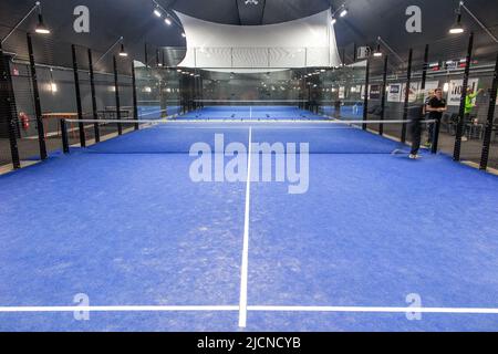 Blick auf einen leeren blauen Padel Court. Padel ist eine Mischung aus Tennis und Squash. Es wird in der Regel im Doppel auf einem geschlossenen Platz gespielt. Stockfoto