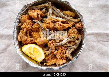 Spanische Meeresfrüchte, knusprig frittierte Babykraken, Fisch, Calamari-Ringe mit Zitrone serviert, Nahaufnahme Stockfoto