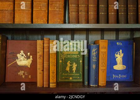 Klassische Bücher mit Stoffbindung auf einem Regal in der Bibliothek im Haus und Garten von Stevens-Coolidge. North Andover, Massachusetts, USA. Stockfoto