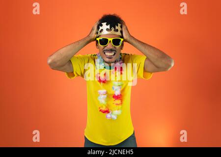 Mann im gelben Fußballoutfit feiert isoliert auf orangefarbenem Hintergrund. Stockfoto