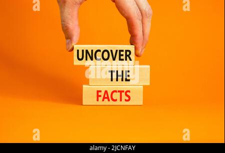 Entdecken Sie das Facts-Symbol. Concept Words Entdecke die Fakten auf Holzblöcken auf einem schönen orangen Tisch orangenen Hintergrund. Geschäftsmann Hand. Unternehmen A Stockfoto