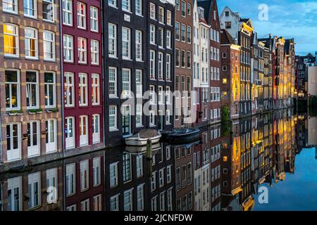 Kanalhäuser am Damrak, im Zentrum der Altstadt von Amsterdam, Hafen, Ausgangspunkt vieler Kanaltouren, Abend, Niederlande, Stockfoto