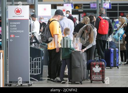 Richmond, Kanada. 14.. Juni 2022. Reisende warten am 14. Juni 2022 auf den Check-in am Vancouver International Airport in Richmond, British Columbia, Kanada. Die kanadische Bundesregierung kündigte am Dienstag an, dass sie die Impfvorschriften gegen COVID-19 für inländische und ausgehende Reisen, staatlich regulierte Verkehrssektoren und Mitarbeiter der Bundesregierung ab Juni 20 aussetzen wird. Quelle: Liang Sen/Xinhua/Alamy Live News Stockfoto