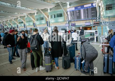 Richmond, Kanada. 14.. Juni 2022. Reisende stehen am 14. Juni 2022 am internationalen Flughafen Vancouver in Richmond, British Columbia, Kanada, an. Die kanadische Bundesregierung kündigte am Dienstag an, dass sie die Impfvorschriften gegen COVID-19 für inländische und ausgehende Reisen, staatlich regulierte Verkehrssektoren und Mitarbeiter der Bundesregierung ab Juni 20 aussetzen wird. Quelle: Liang Sen/Xinhua/Alamy Live News Stockfoto