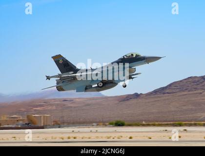 Eine F-16 Fighting Falcon, die der 64. Aggressor Squadron zugewiesen wurde, hebt sich zu einer Routine-Trainingsmission auf der Nellis Air Force Base, Nevada, am 17. Mai 2022 ab. Die AGRS von 64. betreibt 30 F-16C/M-Flugzeuge und stellt realistische, bedrohlich-repräsentative, gegnerische Kräfte für High-End-Schulungen der USA und der Koalition bereit. (USA Foto der Air National Guard von Staff Sgt. Adam Welch) Stockfoto