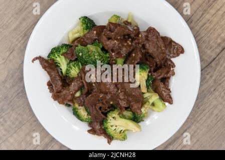 Blick von oben auf Rindfleisch und Brokkoli in herzhafter Sauce glasiert und hoch auf dem Teller für ein großartiges chinesisches Essen gestapelt. Stockfoto