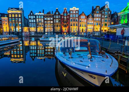 Kanalhäuser am Damrak, im Zentrum der Altstadt von Amsterdam, Hafen, Ausgangspunkt vieler Kanaltouren, Abend, Niederlande, Stockfoto