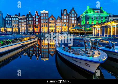 Kanalhäuser am Damrak, im Zentrum der Altstadt von Amsterdam, Hafen, Ausgangspunkt vieler Kanaltouren, Abend, Niederlande, Stockfoto