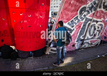 Buenos Aires, Argentinien. 13.. Juni 2022. Ein Zuschauer beobachtet hinter einigen Fahnen und Bannern die Entwicklung der National Picketer Plenary. Die Veranstaltung fand im Obelisk der Stadt Buenos Aires statt, an dem die Delegierten der Picketer-Einheit der 24 argentinischen Provinzen teilnahmen, um die aktuelle Situation zu diskutieren und einen nationalen Plan zur Bekämpfung von Armut und wachsender Arbeitslosigkeit zu erarbeiten. (Foto von Nacho Boullosa/SOPA Images/Sipa USA) Quelle: SIPA USA/Alamy Live News Stockfoto