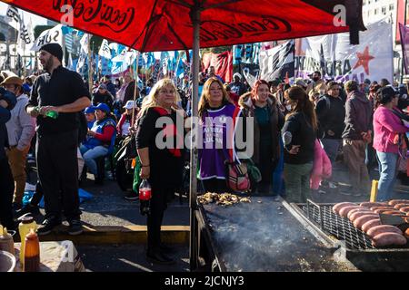 Buenos Aires, Argentinien. 13.. Juni 2022. Zwei Frauen warten auf ihr Mittagessen, das in der National Picketer Plenary unter einer Menschenmenge serviert wird. Die Veranstaltung fand im Obelisk der Stadt Buenos Aires statt, an dem die Delegierten der Picketer-Einheit der 24 argentinischen Provinzen teilnahmen, um die aktuelle Situation zu diskutieren und einen nationalen Plan zur Bekämpfung von Armut und wachsender Arbeitslosigkeit zu erarbeiten. (Foto von Nacho Boullosa/SOPA Images/Sipa USA) Quelle: SIPA USA/Alamy Live News Stockfoto