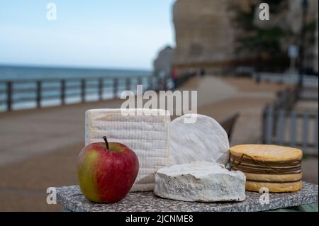 Vier berühmte Käse der Normandie, quadratische pont l'eveque, rund Camembert Kuhkäse, gelbe livarot, herzförmigen neufchatel und Blick auf die Promenade und ein Stockfoto