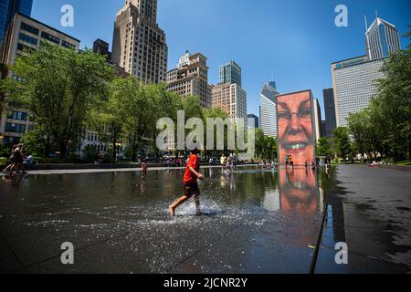 Chicago, USA. 14.. Juni 2022. Ein Junge spielt am 14. Juni 2022 im Crown Fountain in der Innenstadt von Chicago, den Vereinigten Staaten, mit Wasser. Die Metropolregion Chicago ist auf eine Hitzewelle in der Schwebe, da der US-Wetterdienst am Montag eine Wärmeempfehlung für die Region herausgab. Kredit: Vincent D. Johnson/Xinhua/Alamy Live Nachrichten Stockfoto