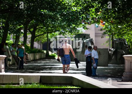 Chicago, USA. 14.. Juni 2022. Ein Mann geht am 14. Juni 2022 mit seinem Hemd in der Innenstadt von Chicago, den Vereinigten Staaten, im Millennium Park. Die Metropolregion Chicago ist auf eine Hitzewelle in der Schwebe, da der US-Wetterdienst am Montag eine Wärmeempfehlung für die Region herausgab. Kredit: Vincent D. Johnson/Xinhua/Alamy Live Nachrichten Stockfoto