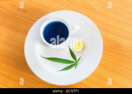 Tasse Marihuana-Kräuter und heißen Zitronentee auf dem Teller. Stockfoto