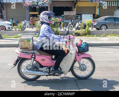 SAMUT PRAKAN, THAILAND, 19 2022. MÄRZ, Eine Frau fährt auf der Stadtstraße mit einem Motorrad Stockfoto