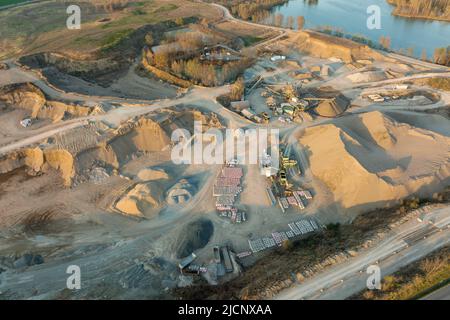 Luftaufnahme der Tagebaumine aus Sandsteinmaterialien für die Bauindustrie mit Baggern und Muldenkipper. Schwere Maschinen im Bergbau und Stockfoto