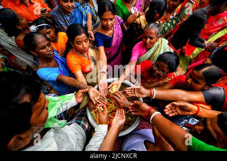 Guptipara, Indien. 14.. Juni 2022. Hinduistische Anhänger breiten ihre Hände aus, als sie vom Priester des Brindaban-Chandra-Tempels Segen von Lord Jagannath erhalten. Ein besonderes Bad von Lord Jagannath findet auf dem Purnima von Jyestha Monat (Devasnan Purnima) statt, um den Erscheinungstag von Lord Jagannath zu gedenken. Laut Skanda Purana, als Raja Indradyumna die hölzernen Gottheiten installierte, arrangierte er diese Badezeremonie. Dieser Tag gilt als der Geburtstag von Lord jagannath. Kredit: SOPA Images Limited/Alamy Live Nachrichten Stockfoto