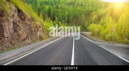 Bergstraße. Landschaft mit Felsen, und schöne Asphaltstraße. Reisehintergrund. Autobahn in den Bergen. Stockfoto