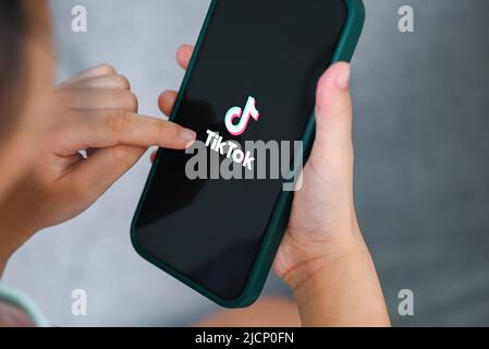 Kind hält Smartphone mit TikTok-Anwendungssymbol auf dem Apple iPhone 13 Pro, TikTok-Logo-Symbol auf dem Bildschirm beliebte Social-Media-Netzwerk aus china, Stockfoto