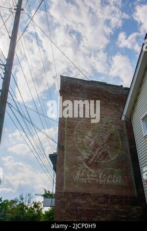 Eine alte Coca-Cola-Anzeige, die auf einer roten Ziegelwand in Butler, Pennsylvania, gemalt wurde. Stockfoto