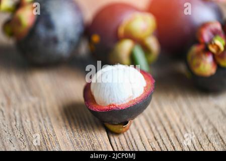 Mangosteen auf Holzhintergrund, frisch reife Mangosteen, die im Sommer bei tropischen Früchten Thailands vom Baum geschält wurden Stockfoto