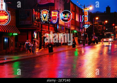 Die neonbeleuchteten Honkey Tonks, Bars und Clubs spiegeln sich im Regen auf der berühmten Beale Street in Memphis Tennessee wider Stockfoto