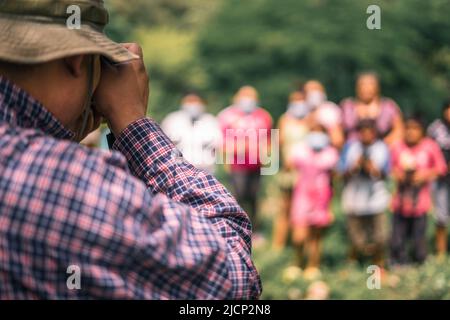 Lateinamerikanischer Fotograf, der ein Bild einer Gruppe von nicht erkennbaren Bauern in Nicaragua machte Stockfoto