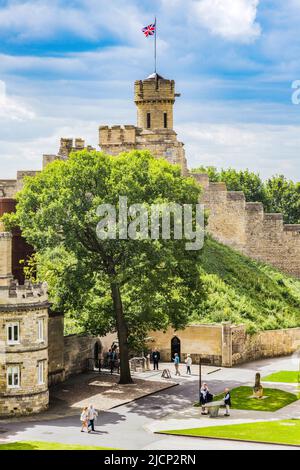 27. Juli 2019: Lincoln, Großbritannien - das Schlossgelände, mit Touristen Sightseeing und einem schönen Baum im vollen Sommerblatt. Stockfoto