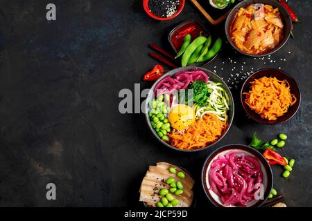 Auswahl an koreanischen Speisen auf dunklem Hintergrund. Asiatische Gerichte und Vorspeisen der Küche. Draufsicht, flach liegend, Kopierbereich Stockfoto