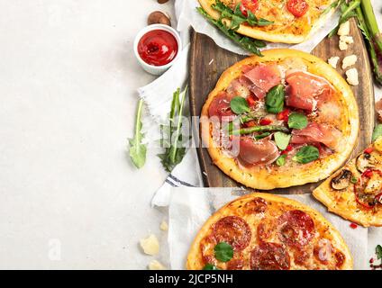 Verschiedene Arten von italienischer Pizza - Margherita, Pepperoni, Schinken, Pilze mit Basilikum, Tomaten, Olivenöl und Käse auf weißem Hintergrund. Draufsicht mit c Stockfoto