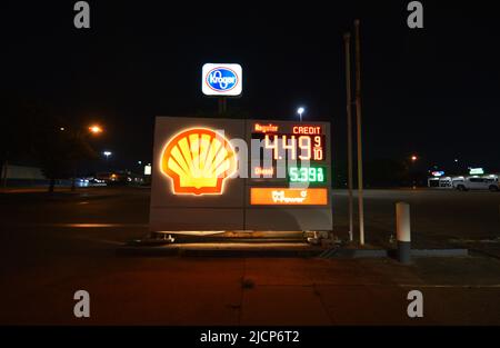 Nachtfoto einer Shell-Tankstelle, Schild mit hohen Gaspreisen und Kroger-Schild im Hintergrund Stockfoto