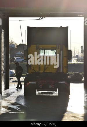 Mann, der am frühen Morgen bei einer LKW-Waschanlage in Irving, Texas, ein Halb-Lkw-Taxi wascht Stockfoto