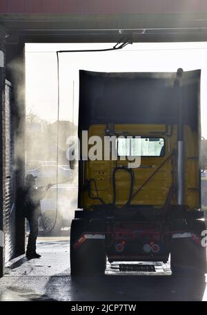 Mann, der am frühen Morgen bei einer LKW-Waschanlage in Irving, Texas, ein Halb-Lkw-Taxi wascht Stockfoto