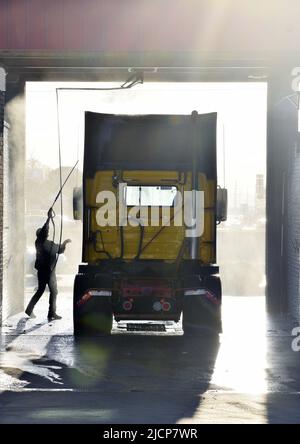 Mann, der am frühen Morgen bei einer LKW-Waschanlage in Irving, Texas, ein Halb-Lkw-Taxi wascht Stockfoto