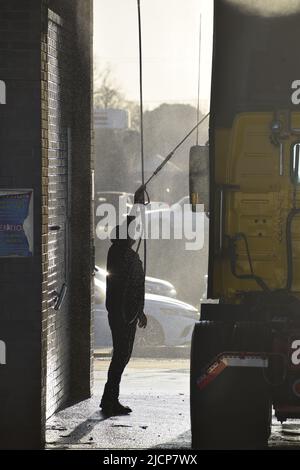 Mann, der am frühen Morgen bei einer LKW-Waschanlage in Irving, Texas, ein Halb-Lkw-Taxi wascht Stockfoto