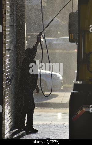 Mann, der am frühen Morgen bei einer LKW-Waschanlage in Irving, Texas, ein Halb-Lkw-Taxi wascht Stockfoto