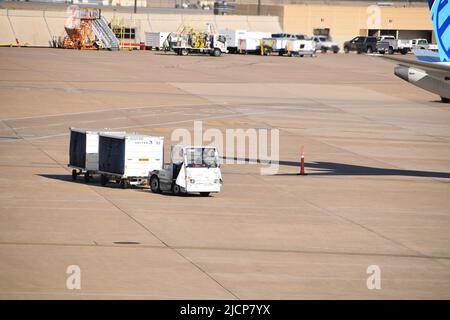 Ein Schlepper von United Airlines, der am Dallas-Fort Worth International Airport (DFW Airport) Gepäckwagen zum Terminal E zieht Stockfoto